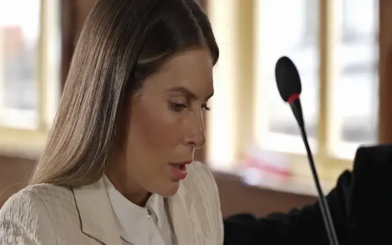 Woman testifying with a microphone.